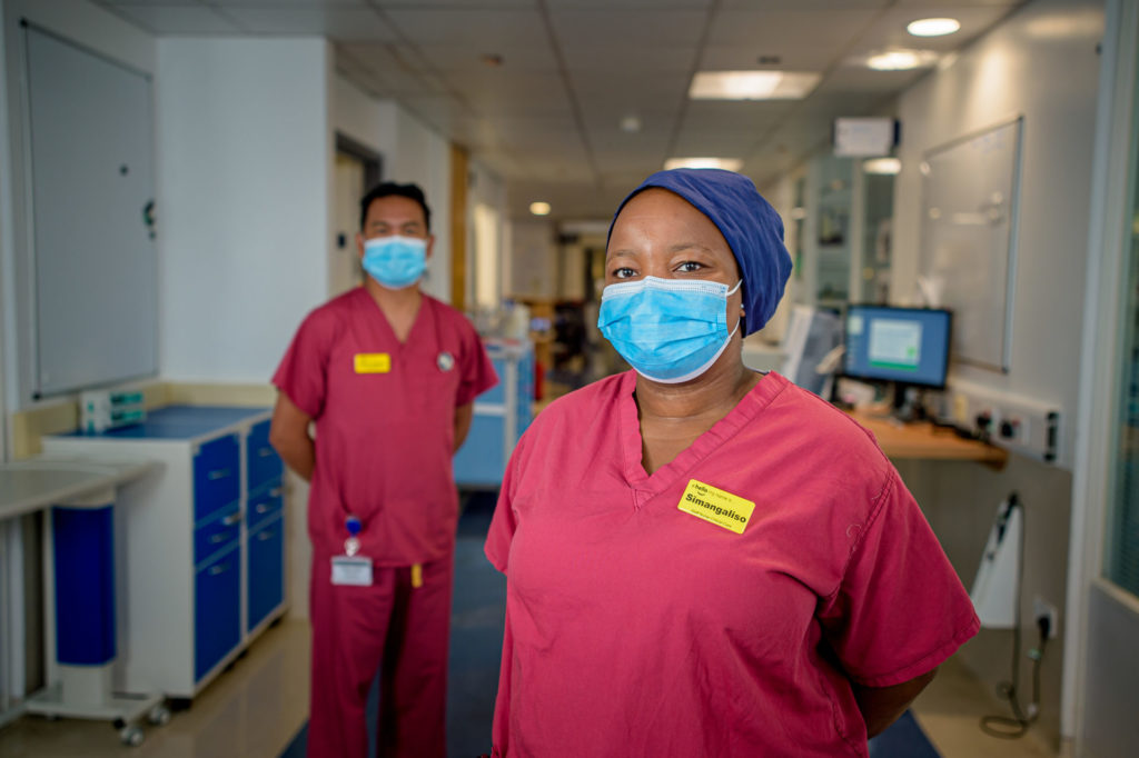 Two nurses in corridor wearing PPE
