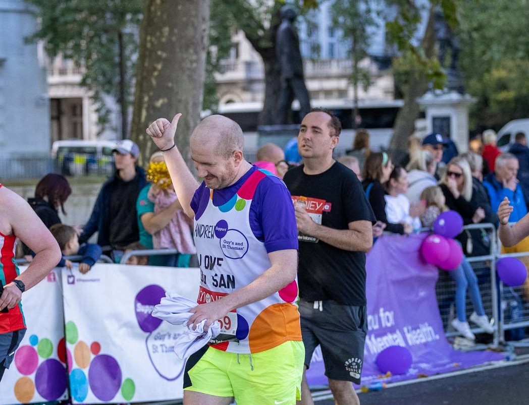 Fundraiser gives thumbs up while running at event