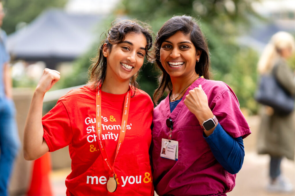 Nurse with fundraiser who abseiled St Thomas hospital celebrating.