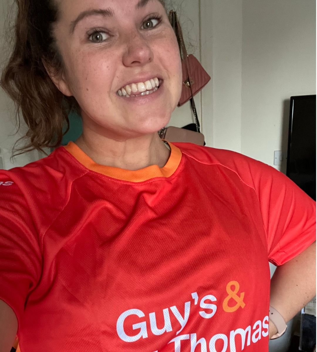 Sarah-Jane wearing a red t-shirt that reads 'Guy's & St Thomas' Charity' on the front.